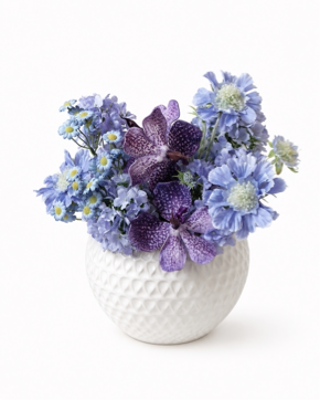 Blue and purple artificial flower arrangement in a white vase